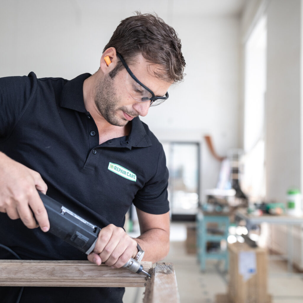 Repair Care Anwendungstechniker repariert Holzfensterrahmen.