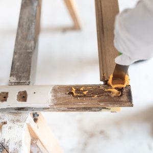 Die Reparaturstelle eines Fensterflügels wird mit DRY FLEX® 1 Holzreparaturspachtel benetzt.