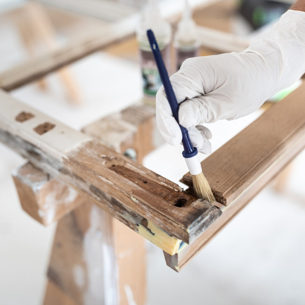 Repair Care Anwendungstechniker trägt DRY FIX® auf die Holzreparaturstelle auf.