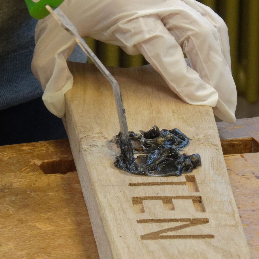 Mit Mixol abgetönter DRY FLEX® 4 Holzspachtel wird in eine ausgefräste Stelle im Holz eingebracht.
