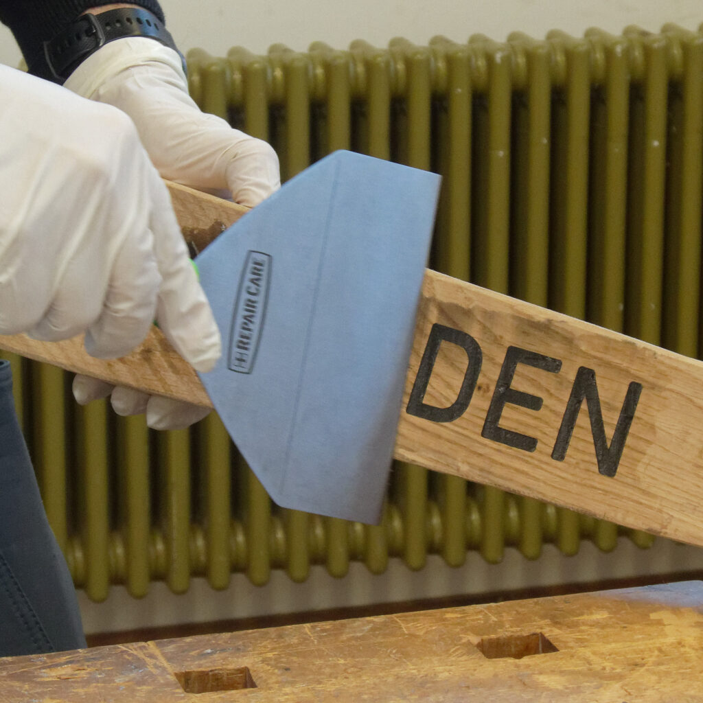 Überschüssiger DRY FLEX® 4 2K-Holzspachtel wird mit dem Modellierspachtel glatt abgezogen, um eine ebene Oberfläche zu erzielen.