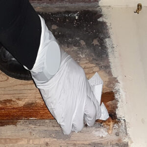 Die mit DRY FIX® UNI behandelte, ausgefräste Stelle auf der Holztreppe wird sorgfältig abgetupft, um überschüssiges Material zu entfernen